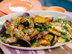 a white bowl filled with lots of food on top of a table