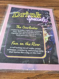 an advertisement for the drink on the river is shown in front of a wooden table