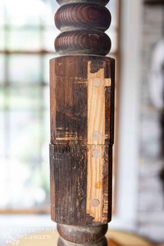 a close up of a wooden pole with a cross on it's end and a window in the background