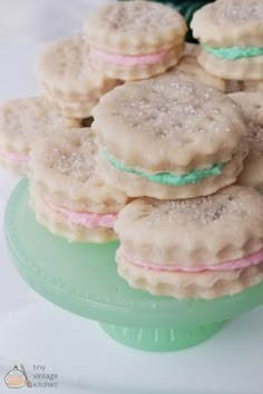 cookies with frosting and pastel on them sitting on a green plate