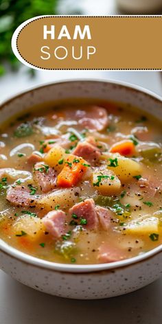 ham soup with potatoes and carrots in a white bowl on a table next to parsley