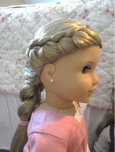 a doll with blonde hair wearing a pink shirt and braids on it's head