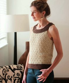 a woman standing in front of a lamp wearing a crocheted top and pants