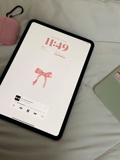 the ipad is sitting on top of the bed next to an earbud and headphones