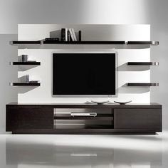 a modern living room with white walls and black entertainment center on the wall, bookshelves and shelves