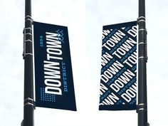 two street flags with the words down town on them