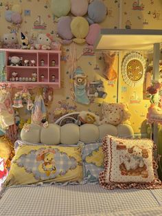 a bed with many pillows and stuffed animals on it