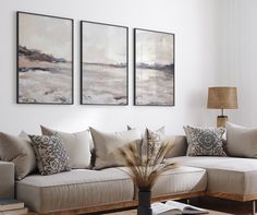 a living room filled with furniture and paintings on the wall above it's coffee table