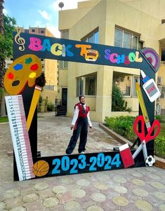 a man standing in front of a mirror with school supplies on it and the words back to school