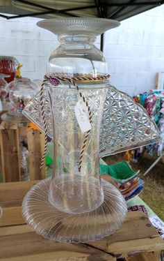 a clear glass vase sitting on top of a wooden table next to a white tag