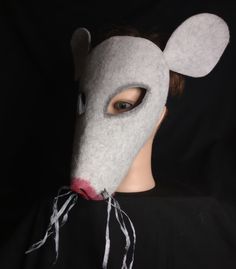 a person wearing a mouse mask on top of a black background with one eye open