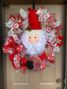 a christmas wreath with a santa clause on the front door and candy canes around it