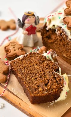 a slice of gingerbread cake sitting on top of a cutting board next to cookies