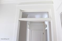 an open door in the corner of a room with white walls and trim around it