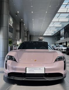 a pink sports car is parked in a showroom