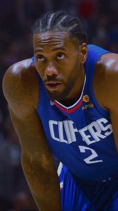 a close up of a basketball player wearing a blue uniform and looking at the camera