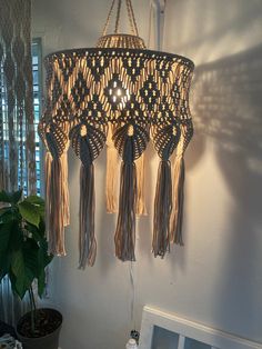 a chandelier with tassels hanging from it's sides in front of a window