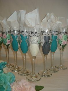 six wine glasses with bride and groom's names painted on the glass are lined up