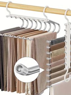 an image of clothes hanging on a rack with metal bars and clips to hang them