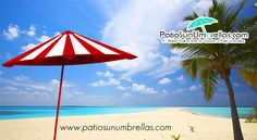 a red and white umbrella sitting on top of a sandy beach