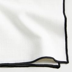 a white and black napkin folded on top of each other with a black border around the edges