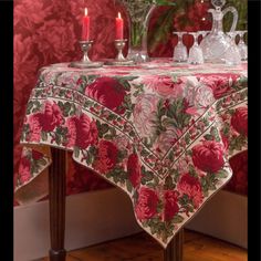 a table topped with a red rose covered table cloth