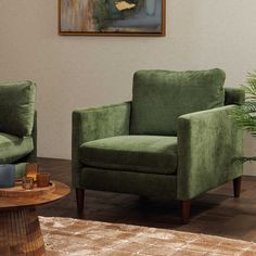 a living room with two green chairs and a coffee table in front of a painting on the wall