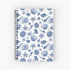 a spiral notebook with blue sea shells and starfishs on white, front view