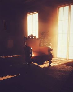 the sun shines through two windows onto a chair