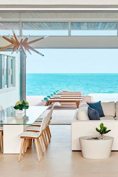 a living room filled with furniture next to the ocean