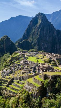 the ruins of machaca picach are surrounded by mountains and greenery in peru