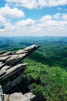 a rocky outcropping on top of a mountain with mountains in the background