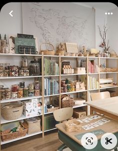 a room filled with lots of books and baskets next to a whiteboard on the wall