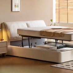 a bed that is sitting in the middle of a room with a pull out table underneath it