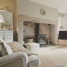 a living room filled with furniture and a fire place next to a wall mounted tv