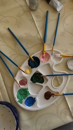 several paints and brushes are sitting on a tray