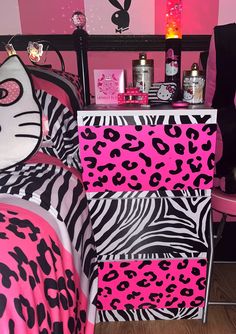 a bedroom decorated in pink, black and white with an animal print bedding set