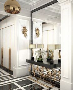 a black and white marble floor with gold accents on the mirror, chandelier and table