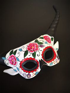 Immerse yourself in the joyous spirit of the Day of the Dead with our captivating horned women's masquerade mask with a stunning floral sugar skull design. This mask captures the essence of the vibrant celebration, giving your look a touch of festivity. The vibrant colors add an air of joyful celebration, allowing you to stand out with colorful grace at Dia de los Muertos celebrations. Age Group/Gender - Adult/Women Size/Type - One size fits all adults Mask Material - Polyresin Accent Material - Mask With Horns, Horned Mask, Sugar Skull Mask, Masquerade Mask Women, Couples Masquerade Masks, Masquerade Ball Party, Masquerade Ball Mask, Mexican Mask, Metal Mask