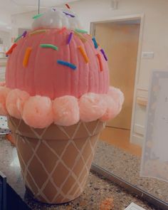 an ice cream cone with sprinkles on it sitting on a counter top