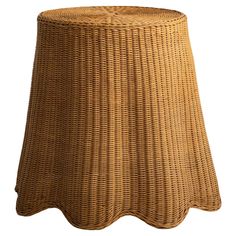 a brown wicker stool with scalloped edges on an isolated white background for use as a side table