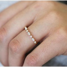 a woman's hand with a diamond ring on top of her finger and the other hand holding it