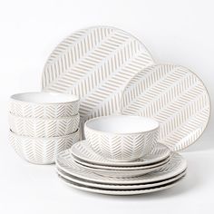 a set of white dishes and plates on a white background