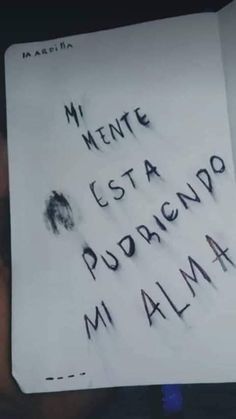 a hand holding up a piece of paper with writing on it that says, mi mente esta podarando mi alma