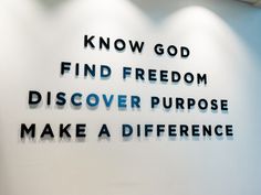 there is a sign on the wall that says know god find freedom, discovery, purpose and make a difference