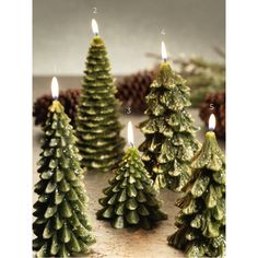 small christmas trees with candles in them on a table