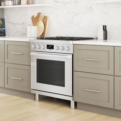 a stove top oven sitting inside of a kitchen next to counter tops and cabinets with utensils on it