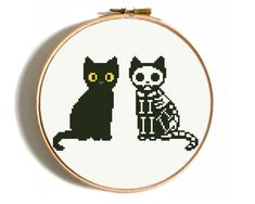 a cross stitch pattern with a black cat and a skeleton sitting next to each other