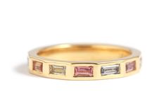 a yellow gold band with pink and white stones