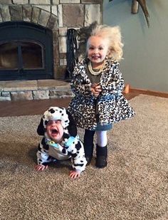 two children dressed up as dalmatian dogs in front of a fireplace